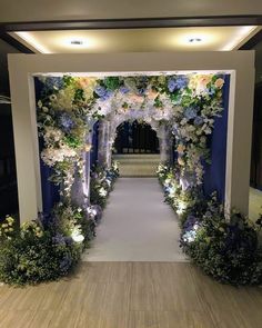 an archway decorated with flowers and greenery for a wedding or event ceremony in the evening