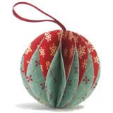 a red and green ornament with snowflakes hanging from it's side