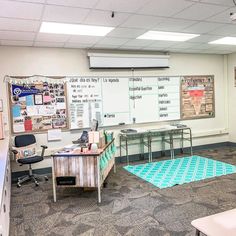 an office with two desks and chairs in front of a whiteboard on the wall