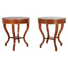 a pair of wooden tables with glass top on each side and gold trim around the edges