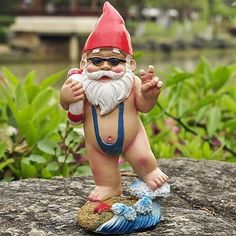 a statue of a little gnome sitting on top of a rock