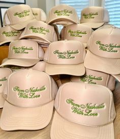 many hats are stacked on top of each other with green lettering that says, from nashville to miss you