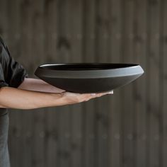 a person holding a black plate in their hand