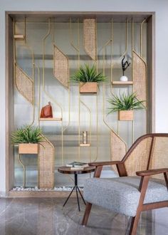 two chairs in front of a glass wall with plants on it