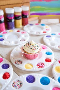 a cupcake on a plate with sprinkles and hearts in the background