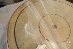 a wooden table with an umbrella painted on it's side and some white cloth