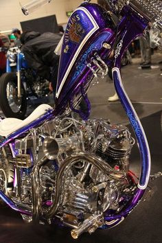 a purple motorcycle parked on top of a black floor