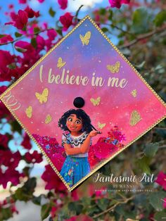 an ornament hanging from the side of a tree with flowers in the background