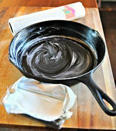 a skillet with melted chocolate in it sitting on a cutting board next to a napkin