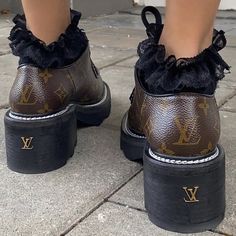 the legs and shoes of a woman wearing louis vuitton boots with ruffles