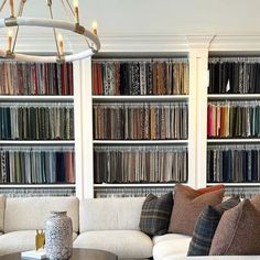 a living room filled with lots of furniture and bookshelves covered in many different types of fabrics