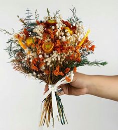 a person holding a bouquet of flowers in their hand