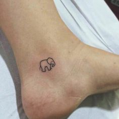 an elephant tattoo on the foot of a woman's left leg is shown in black ink