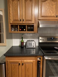 a kitchen with stainless steel appliances and wooden cabinets, including a toaster oven on the counter