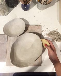 a person is making bowls on a table