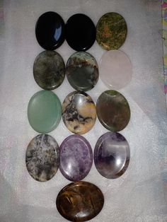 several different types of stones sitting on top of a white cloth covered table next to each other