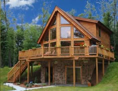 a large wooden house sitting on top of a lush green hillside