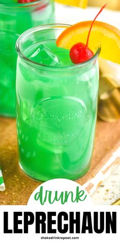 two glasses filled with green liquid and garnished with cherries on the rim