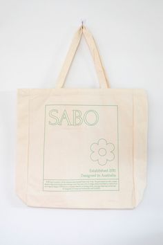 The perfect bag for weekend farmers markets! The Sabo Tote Bag is made from a natural cream canvas and features long arm straps and green printed detailing. The perfect alternative to plastic bags! Eco-friendly Beige Canvas Bag With Double Handle, Organic Rectangular Canvas Bag For Everyday Use, Eco-friendly Natural Canvas Bag With Double Handle, Eco-friendly Cream Canvas Bag For Everyday Use, Organic Everyday Tote Bag, Everyday Organic Tote Bag, Eco-friendly Cream Canvas Travel Bag, Organic White Bags For Everyday Use, Organic White Reusable Bag