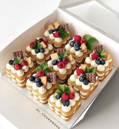 a box filled with lots of small desserts on top of a white countertop