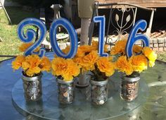 the table is decorated with mason jars and flowers for someone's 60th birthday party