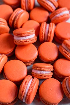 an assortment of orange macaroons on display