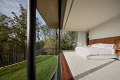 a bedroom with a large bed sitting on top of a lush green field next to a balcony