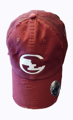 a maroon hat with white letters on it and a button in the middle of the cap