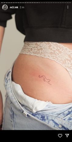 a woman's stomach with a small tattoo on it