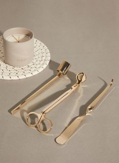 a pair of scissors, a cup and some other items sitting on a table next to each other