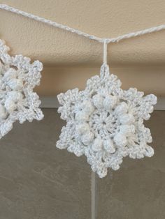 two crocheted snowflakes hanging from the ceiling