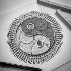 a black and white drawing of a yin - yang symbol on paper with marker pens