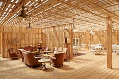 the inside of a restaurant with wooden walls and chairs, tables, and lamps hanging from the ceiling