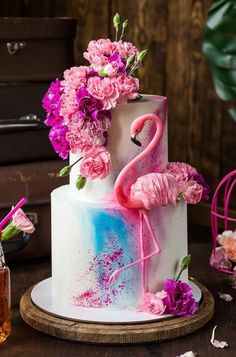 a cake decorated with pink flowers and flamingos