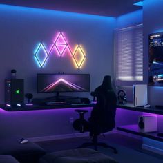 a person sitting in front of a tv on top of a desk next to a monitor