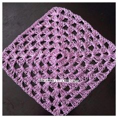 a purple crocheted square on top of a table