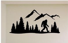 a bigfoot is walking through the woods with mountains in the background