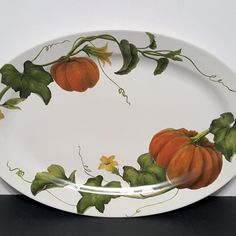 a white plate with pumpkins painted on it