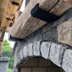 an oven built into the side of a stone building with a black handle on it