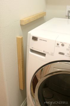 a washer and dryer sitting next to each other in a room with white walls