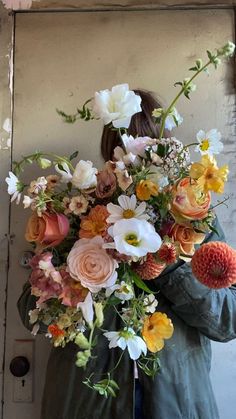 a woman holding a large bouquet of flowers