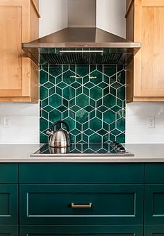 a teal kitchen with wooden cabinets and stainless steel range hood