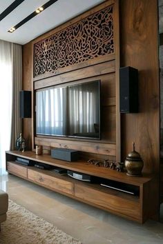 a living room with a large tv on the wall and wooden paneling around it