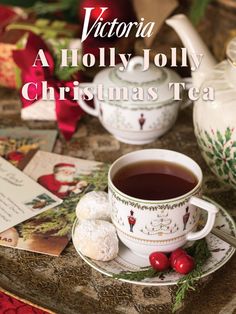 a cup of tea and some cookies on a table with the words victoria aldily jolly christmas tea