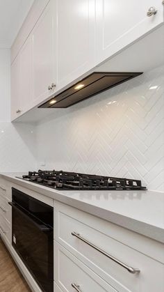 a kitchen with white cabinets and an oven