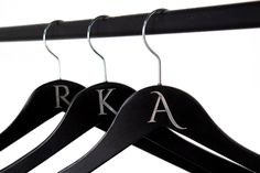 two black wooden hangers with letters on them