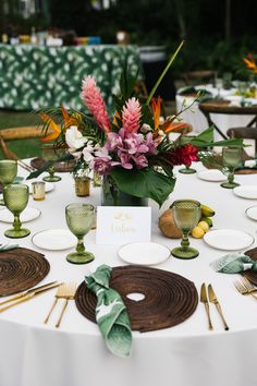 a table set with place settings and flowers