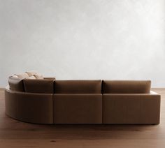 a couch sitting on top of a hard wood floor next to a white wall in an empty room