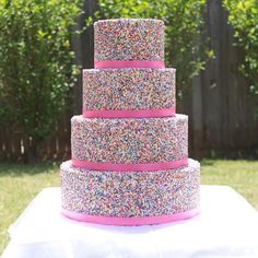 a three tiered cake with sprinkles on it