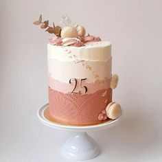 a pink and white cake sitting on top of a table